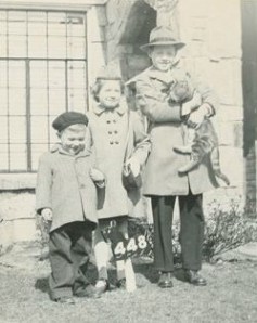 Black and white photo of three siblings in Front of House